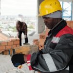 mature-builder-with-electric-drill-carrying-out-his-work-unfinished-building